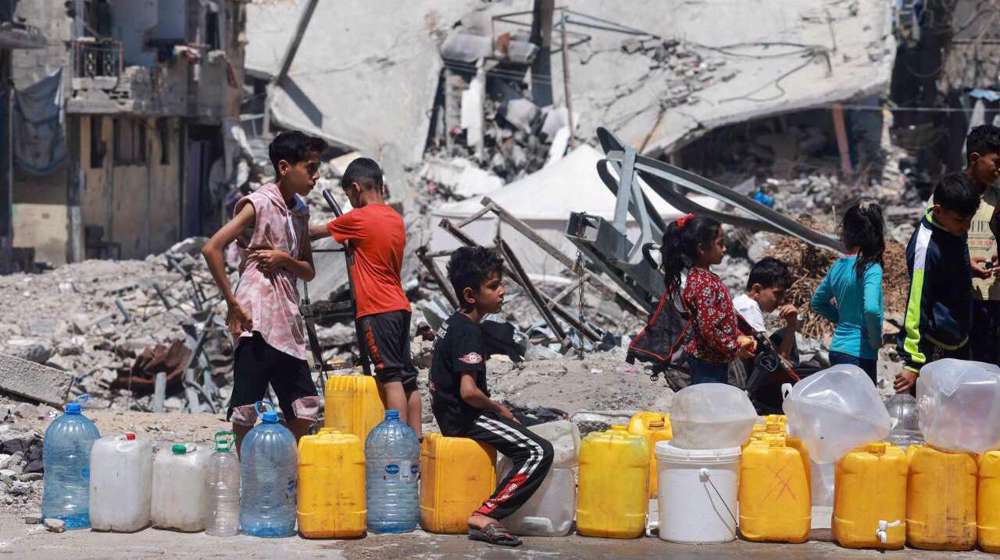 Niños palestinos hacen cola para conseguir agua en Gaza