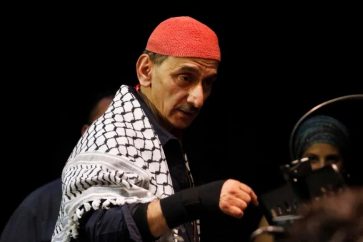 El músico y compositor libanés Ziad Rahbani actúa durante un concierto en la ciudad portuaria de Sidón, en el sur del Líbano, vistiendo la kufiya palestina, el 9 de octubre de 2014 [Archivo: Ali Hashisho/Reuters]